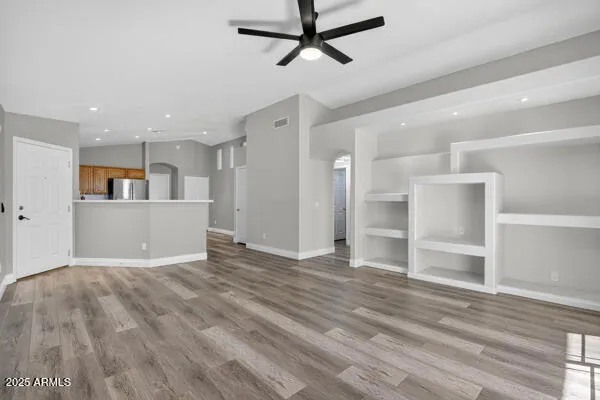 a view of a kitchen with wooden floor and a ceiling fan
