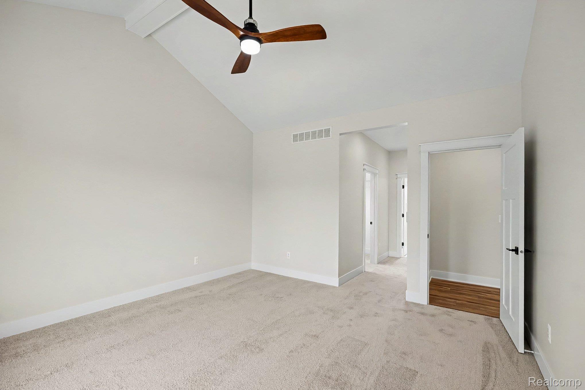 57560 Omo Road Ray, MI 48096 - Photo 18 of 44 Spacious room featuring vaulted ceilings, light neutral wall tones, and plush carpet flooring