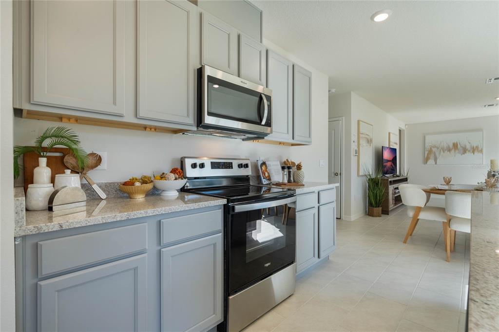 4201 Evernia Road Tavares, FL 32778 - Photo 12 of 25 a kitchen with stainless steel appliances granite countertop a sink stove and cabinets