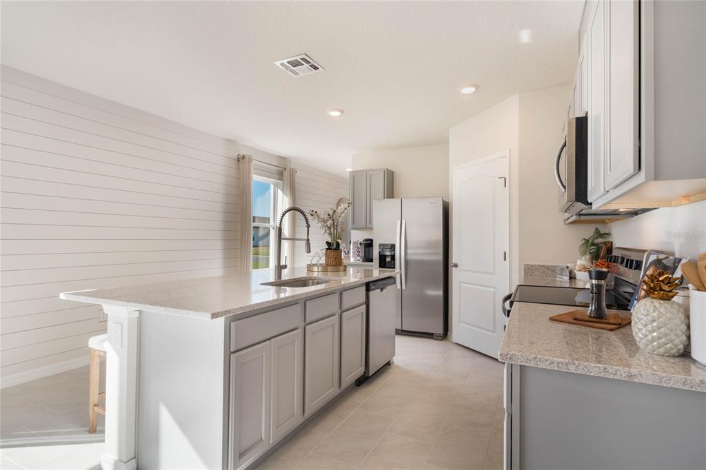 4201 Evernia Road Tavares, FL 32778 - Photo 13 of 25 a kitchen with stainless steel appliances a sink stove and refrigerator