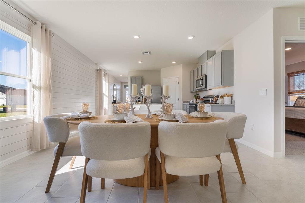 4201 Evernia Road Tavares, FL 32778 - Photo 4 of 25 a dining room with furniture a window and kitchen view