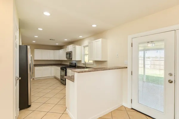 a open kitchen with kitchen island a sink a stove and a refrigerator