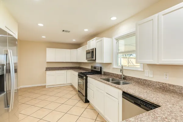 a kitchen with stainless steel appliances granite countertop a sink and a stove