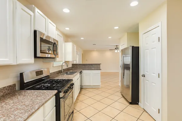 a kitchen with a stove a refrigerator and a sink