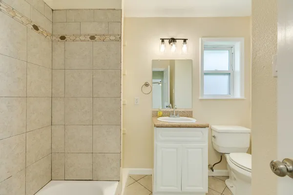 a bathroom with a toilet sink vanity and mirror