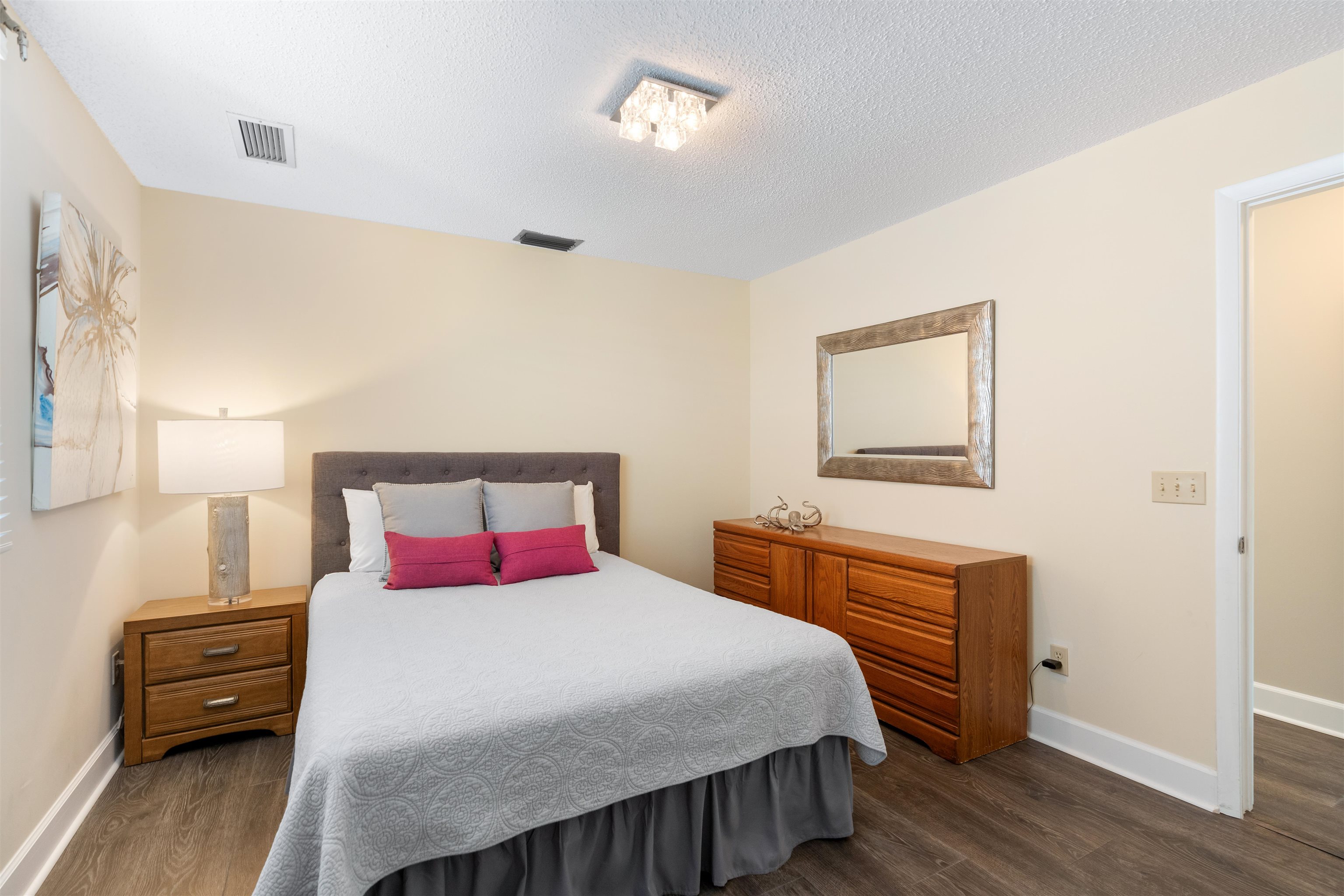 5424 Atlantic View St. Augustine, FL 32080 - Photo 24 of 42 a bedroom with a bed and a dresser with wooden floor
