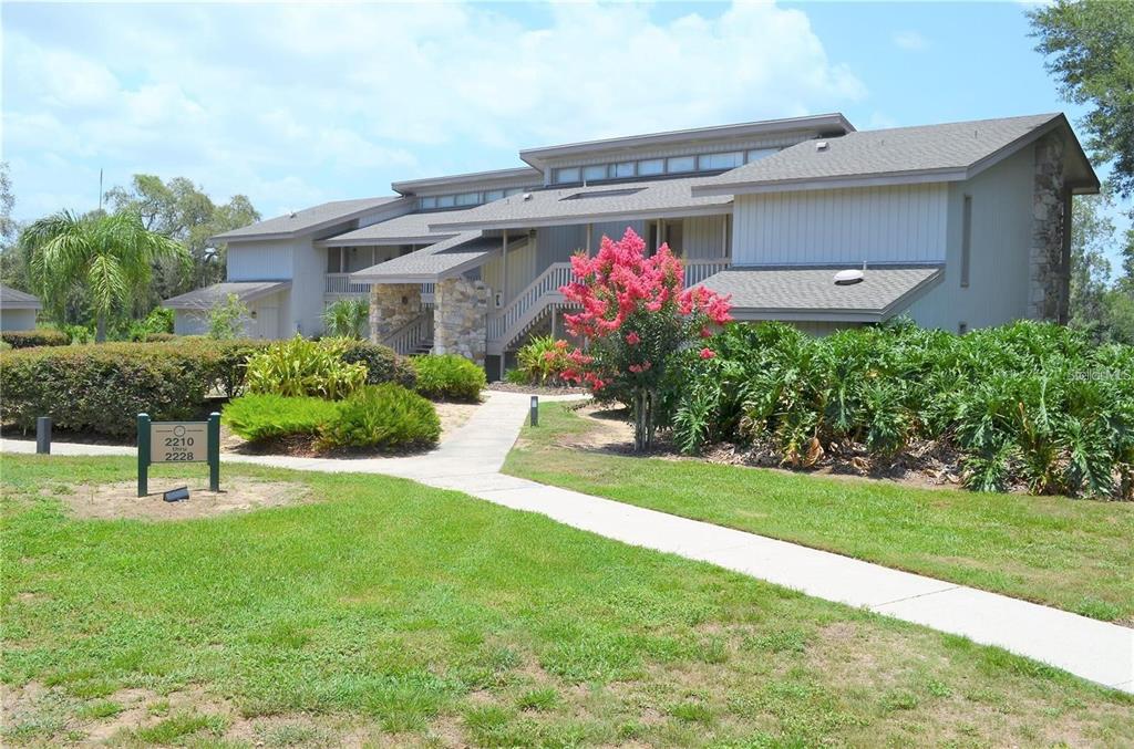 2220 Burnway Road, Unit 2220 Haines City, FL 33844 - Photo 1 of 16 a front view of a house with a yard and potted plants