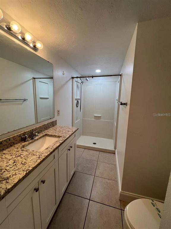 2220 Burnway Road, Unit 2220 Haines City, FL 33844 - Photo 5 of 16 a bathroom with a granite countertop sink toilet and shower