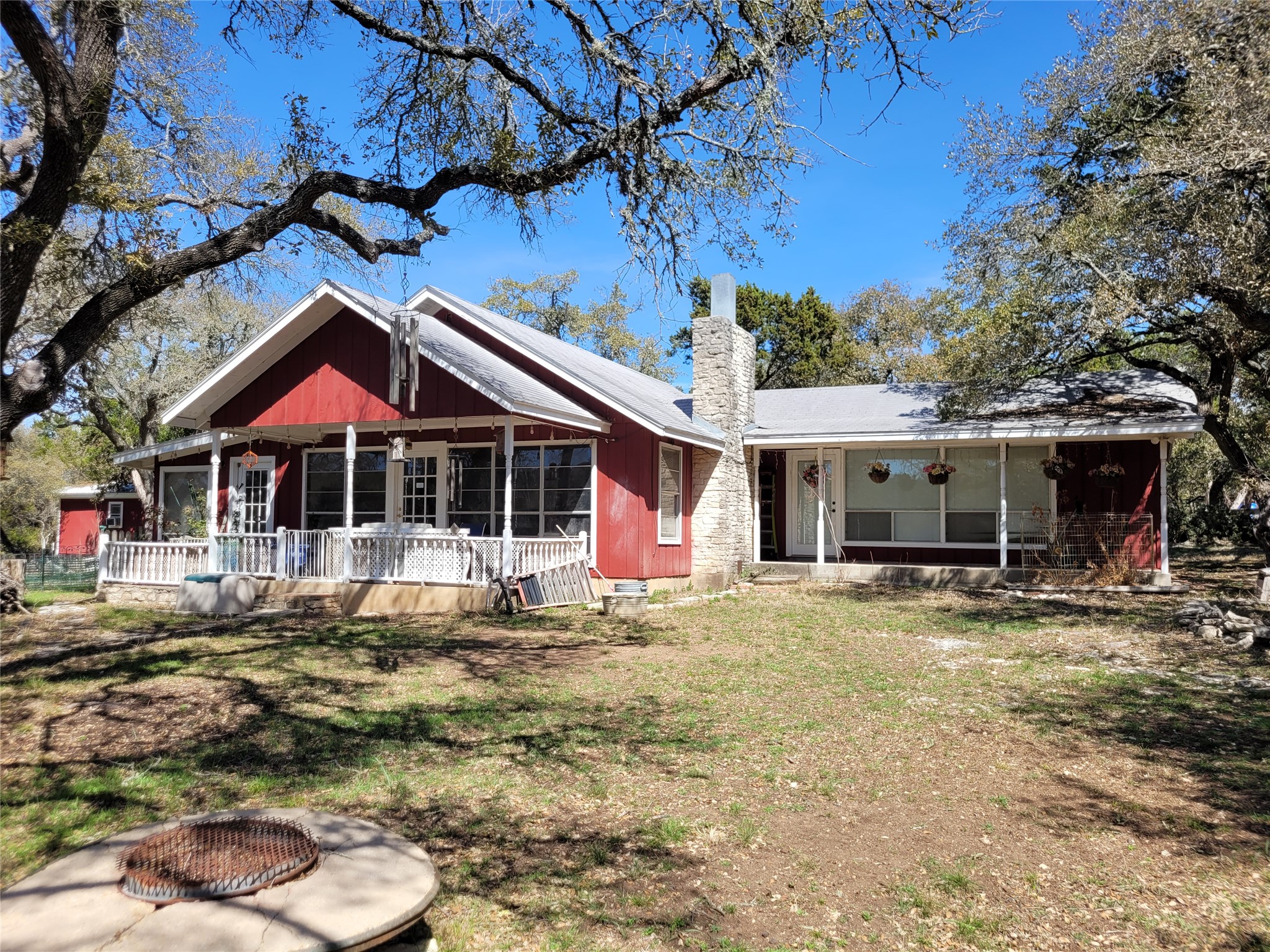 702 Cottonwood Creek Road Dripping Springs, TX 78620 - Photo 5 of 31 Rear view of house featuring a chimney, a porch, and a yard