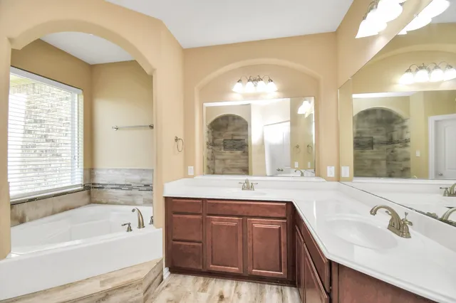 a bathroom with a tub sink and mirror