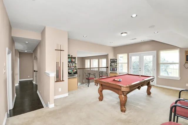 a room with pool table and windows