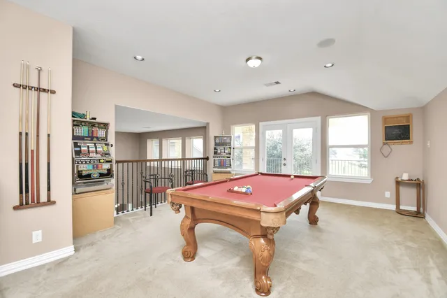 a room with pool table and windows