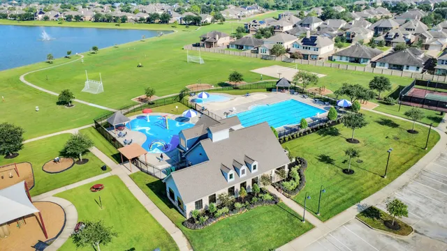 an aerial view of a pool a yard lake and outdoor seating