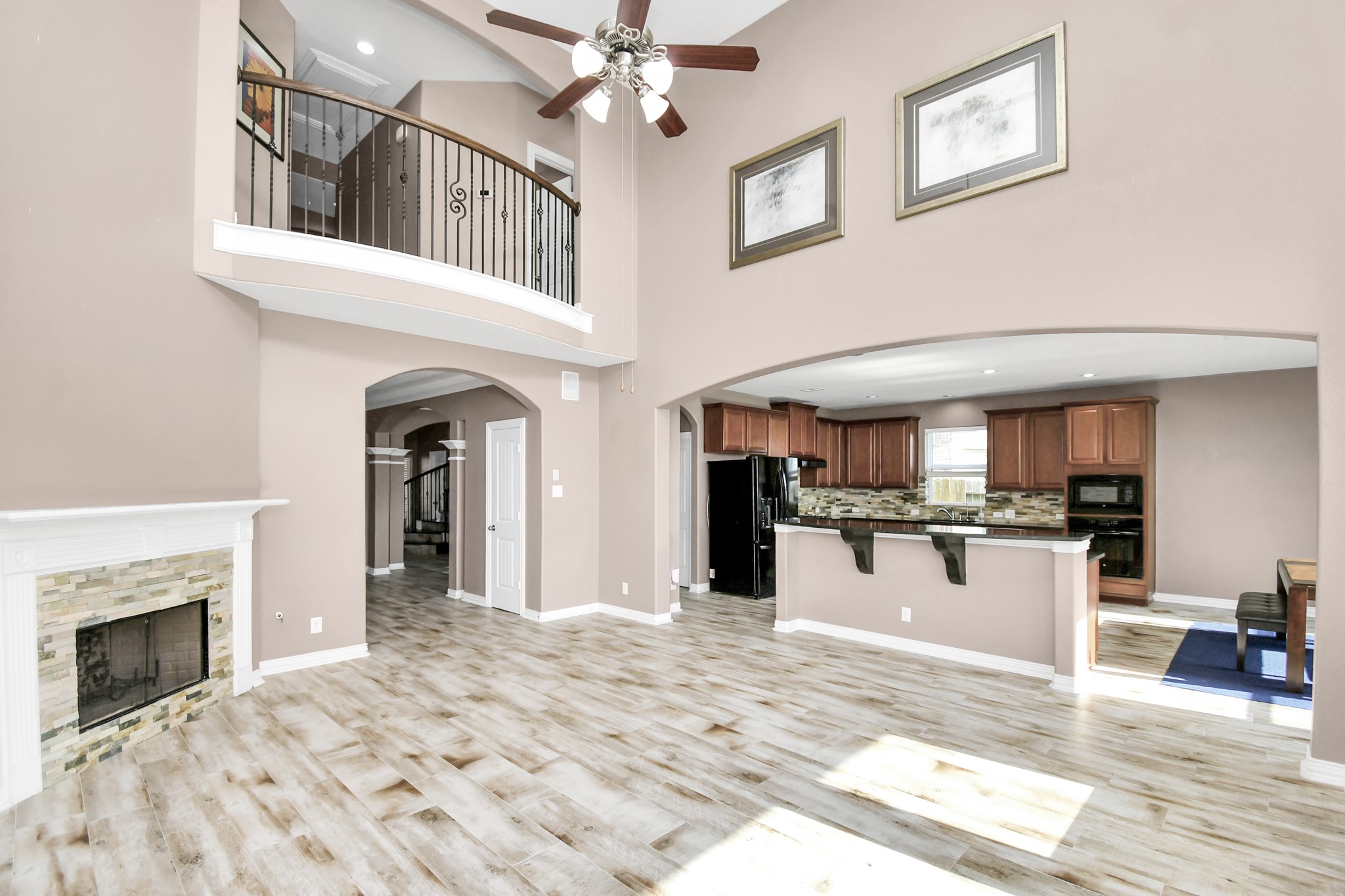 9511 Emerald Lakes Drive Rosharon, TX 77583 - Photo 8 of 38 a view of a livingroom with a fireplace a kitchen island wooden floor and ceiling fan