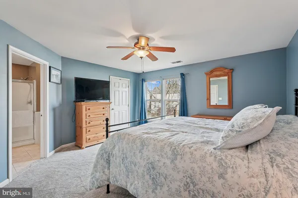 a spacious bedroom with a bed and a chandelier