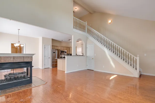 a view of a livingroom with wooden floor and a kitchen