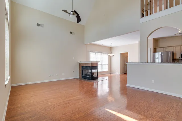 a view of empty room with fireplace and wooden floor