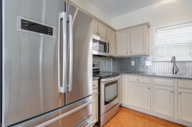 a kitchen with stainless steel appliances granite countertop a refrigerator and a sink