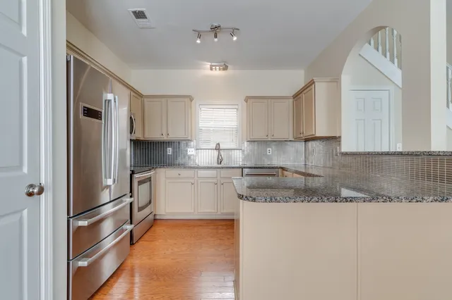 a kitchen with granite countertop cabinets and refrigerator