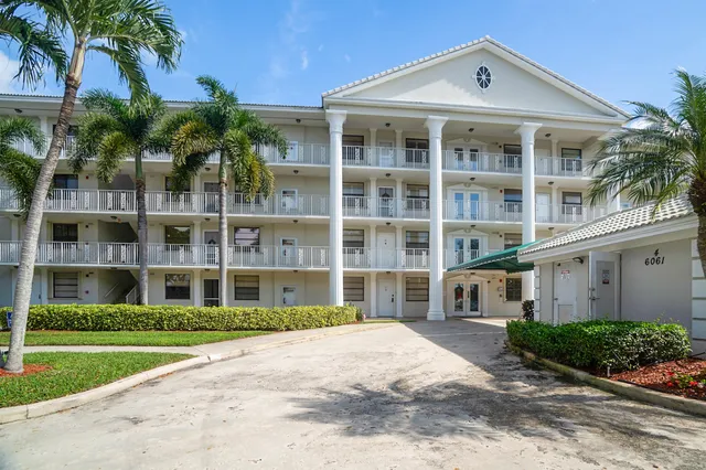 a front view of a house with a yard and potted plants