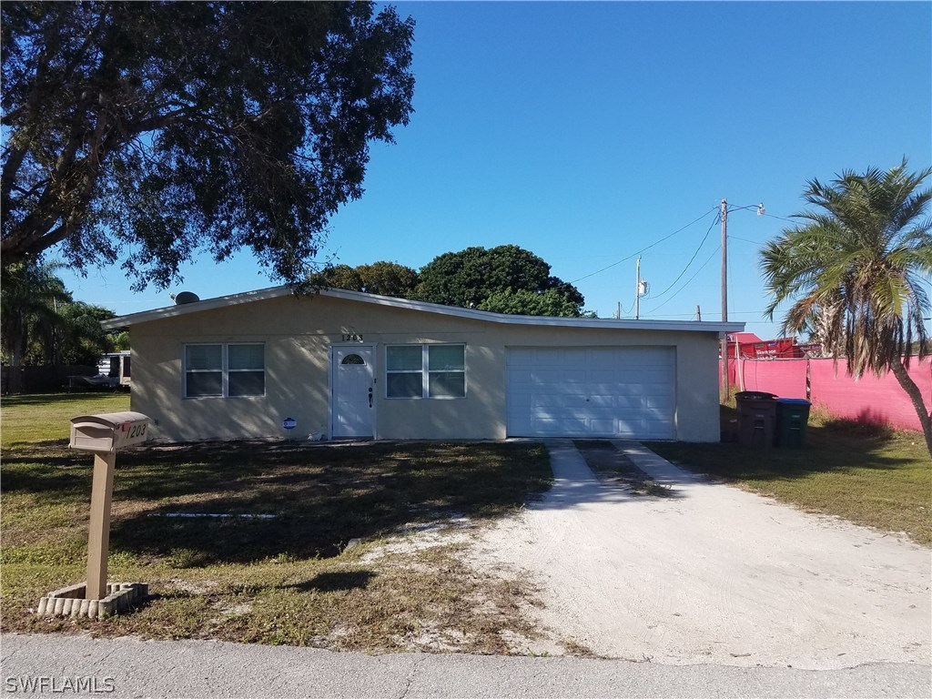 1203 Patterson Road Cape Coral, FL 33909 - Photo 1 of 3 a front view of a house with a yard