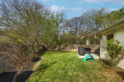a view of a yard with a house and a large tree