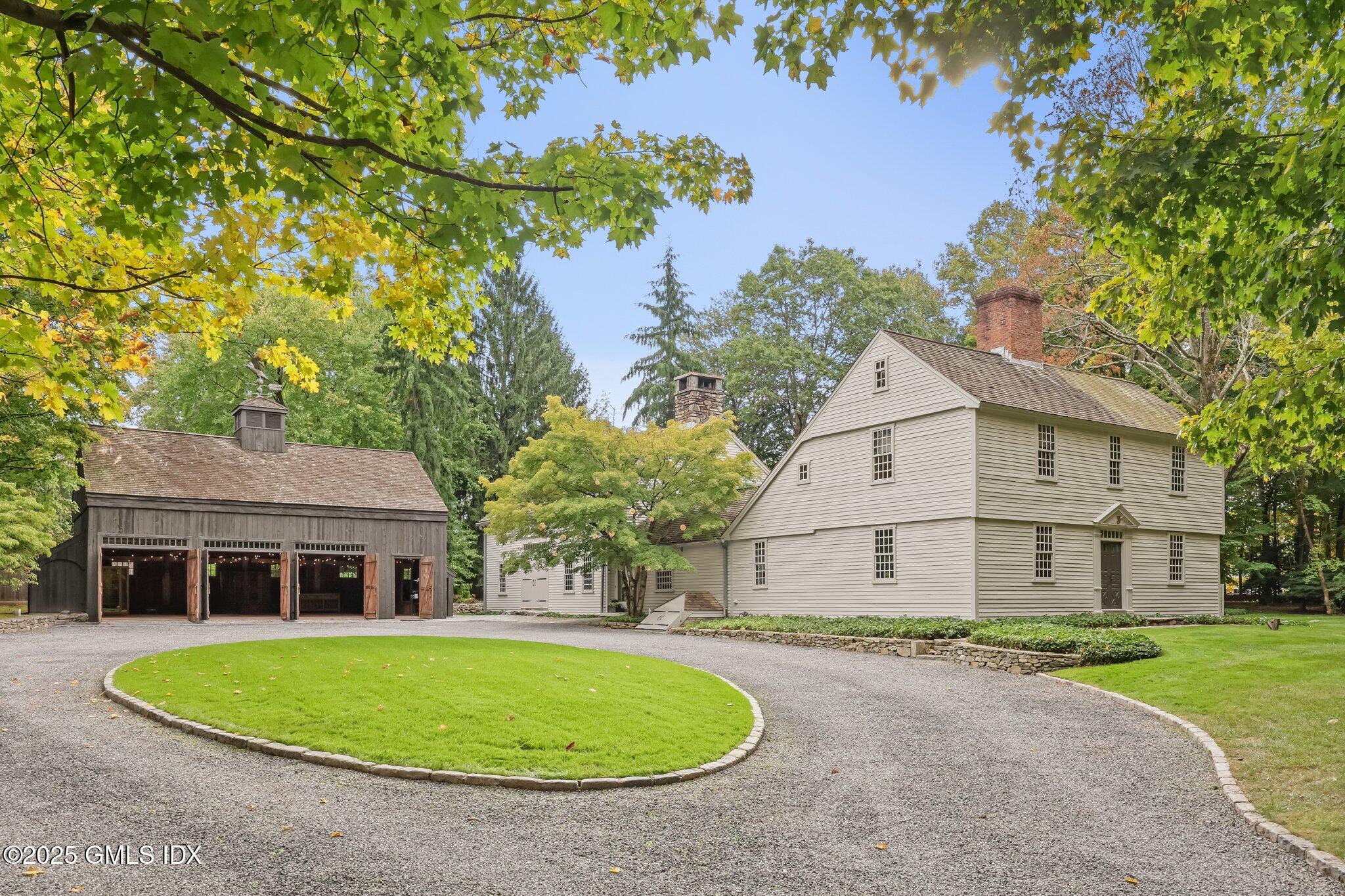 a front view of a house with a garden and trees