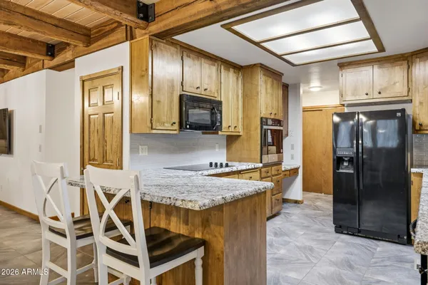 a kitchen with stainless steel appliances granite countertop a refrigerator and a stove top oven