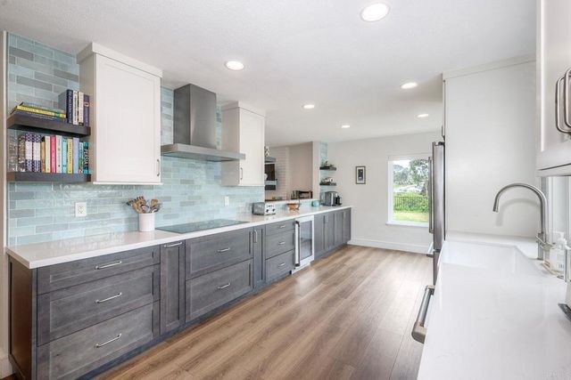 a kitchen with stainless steel appliances granite countertop a sink cabinets and wooden floor