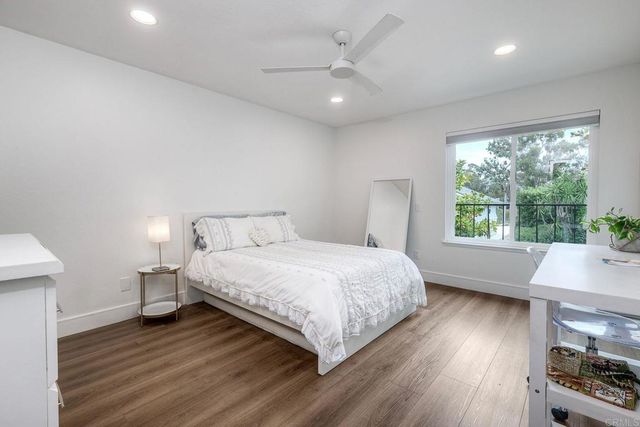 a bathroom with a toilet sink vanity granite and shower
