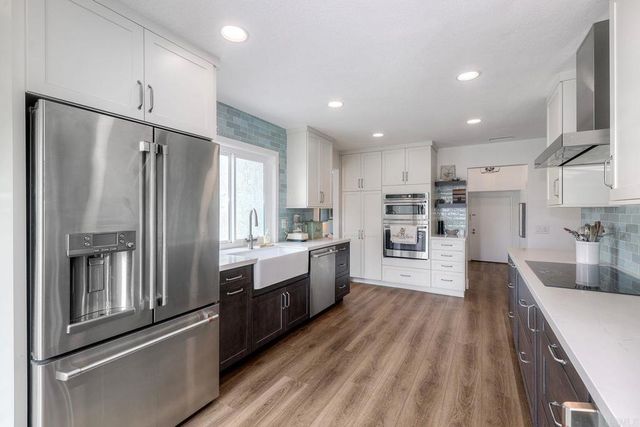 a large kitchen with stainless steel appliances and a refrigerator