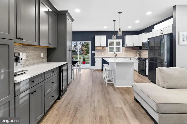 a kitchen with stainless steel appliances a refrigerator a stove a sink cabinets and wooden floor