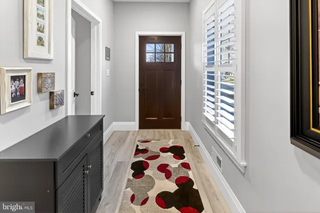 a walk in closet with wooden floor