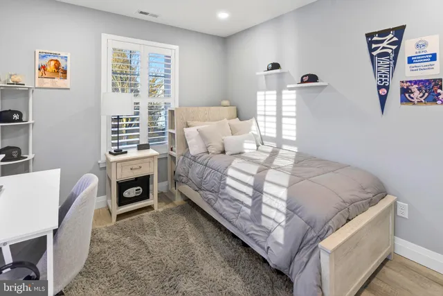 a view of a bedroom with a bed and wooden floor
