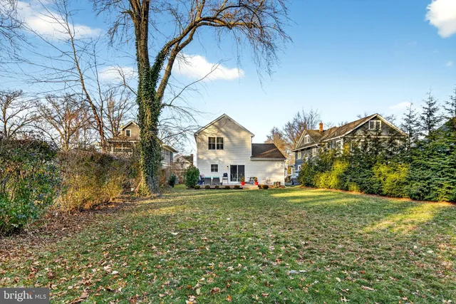 a view of a house with a big yard and large trees