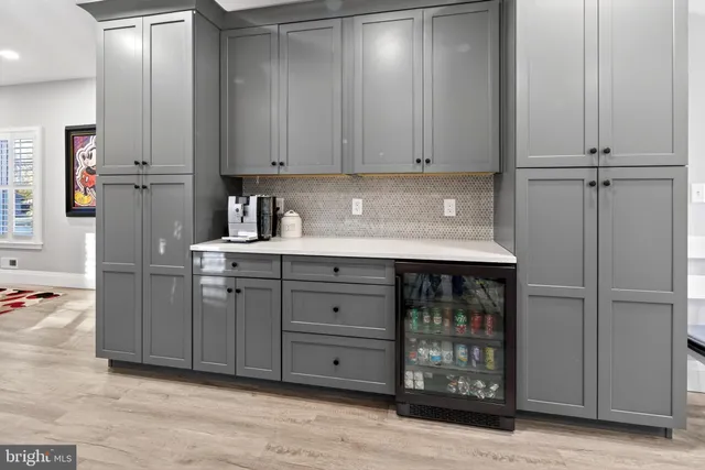 a kitchen with stainless steel appliances granite countertop a refrigerator a sink dishwasher a stove and white cabinets with wooden floor