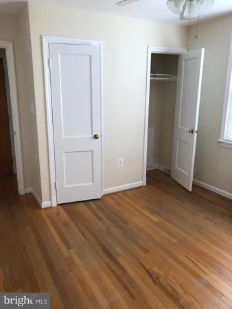 an empty room with wooden floor and closet