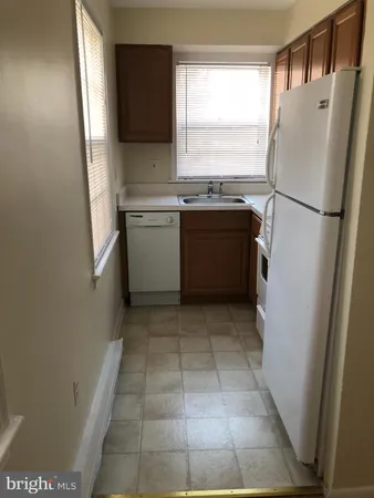a kitchen with a refrigerator sink and cabinets