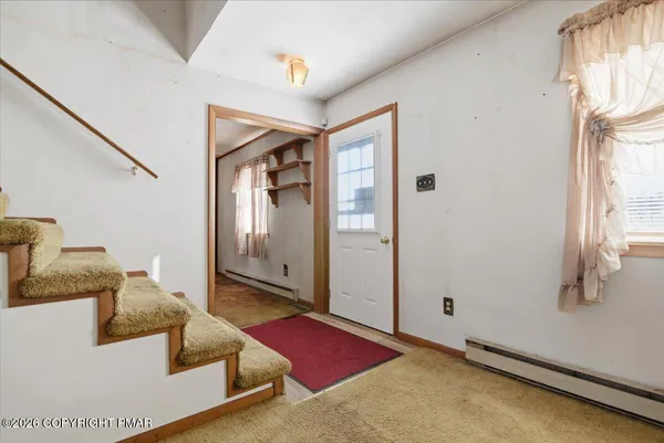 an empty room with ceiling fan and window