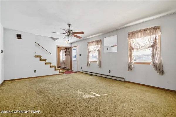 an empty room with closet and a chandelier fan