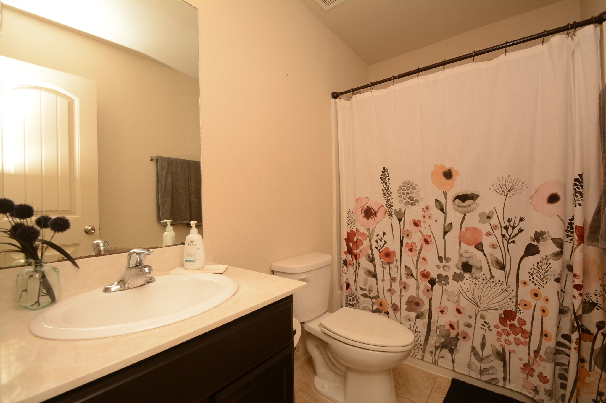 23318 Dukes Run Drive Spring, TX 77373 - Photo 21 of 41 This bathroom features a clean, modern design with a white sink and countertop, and dark cabinetry. The light walls and tile flooring add a bright and welcoming touch.