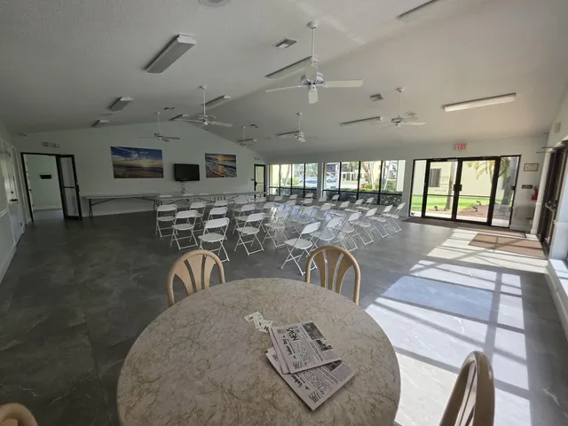 a view of a dining room with furniture a kitchen and chandelier