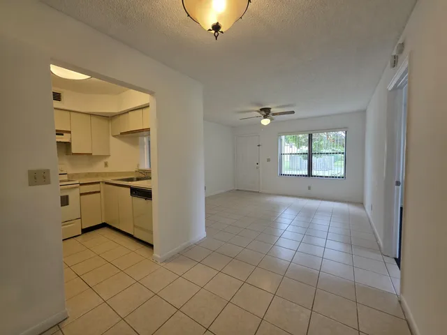 a view of a kitchen with a sink a stove top oven and cabinets