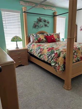 a bed sitting in a bedroom next to a window
