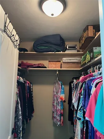 a view of walk in closet with clothes and shoes