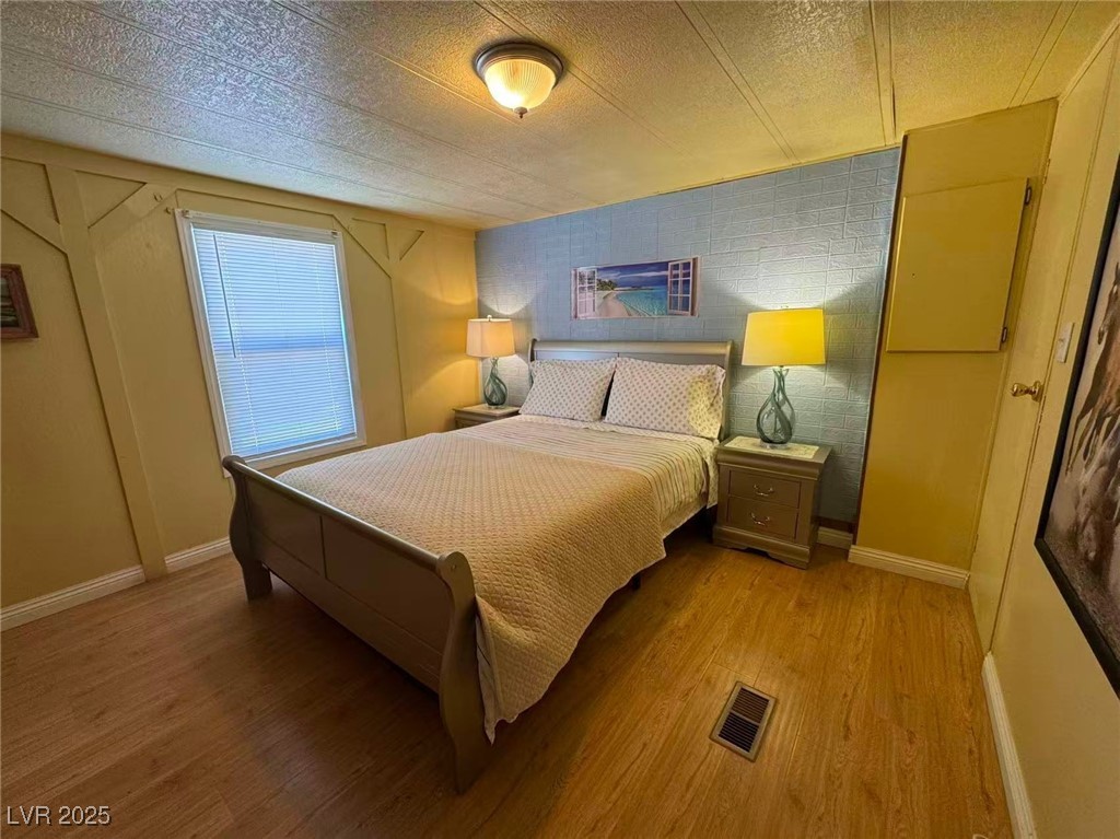551 Piltz Road Pahrump, NV 89060 - Photo 11 of 22 Bedroom featuring wood finished floors and a textured ceiling