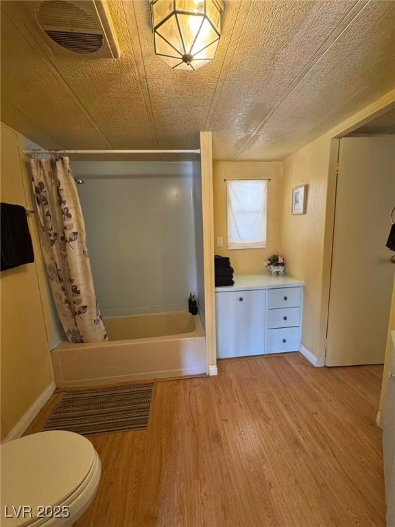 551 Piltz Road Pahrump, NV 89060 - Photo 12 of 22 Full bathroom with shower / bath combo with shower curtain, light wood-style flooring, and a textured ceiling