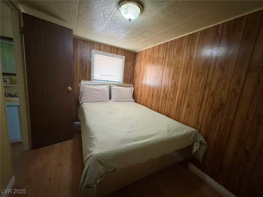 551 Piltz Road Pahrump, NV 89060 - Photo 13 of 22 Bedroom with wood finished floors and wood walls