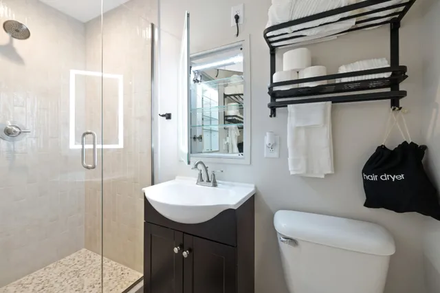 a bathroom with a sink a toilet and shower