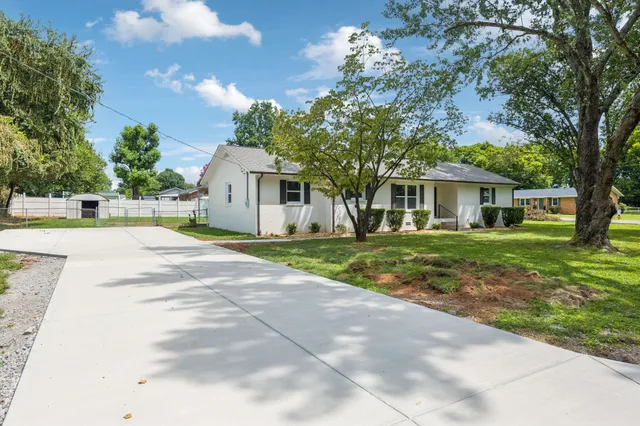 a front view of a house with a yard and trees
